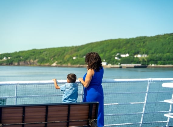 A mother and son look out over the railing on the MV Fundy Rose