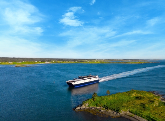 The CAT ferry navigates a narrow stretch of ocean near the land